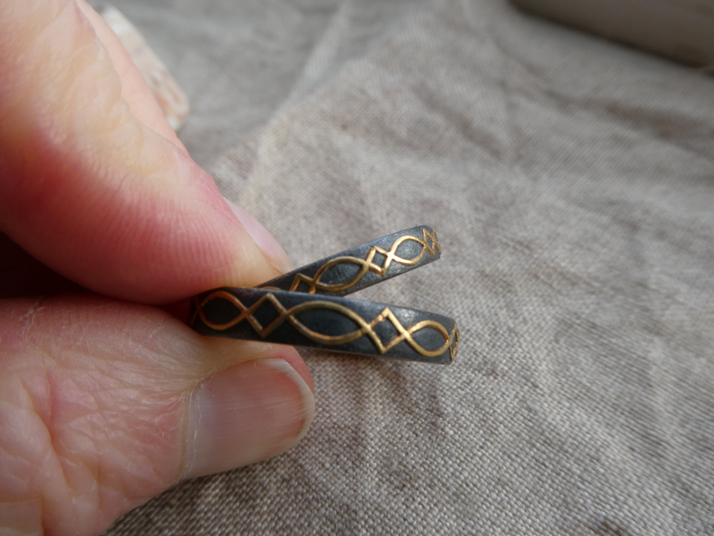 gold inlaid wedding bands with design set against blackened silver