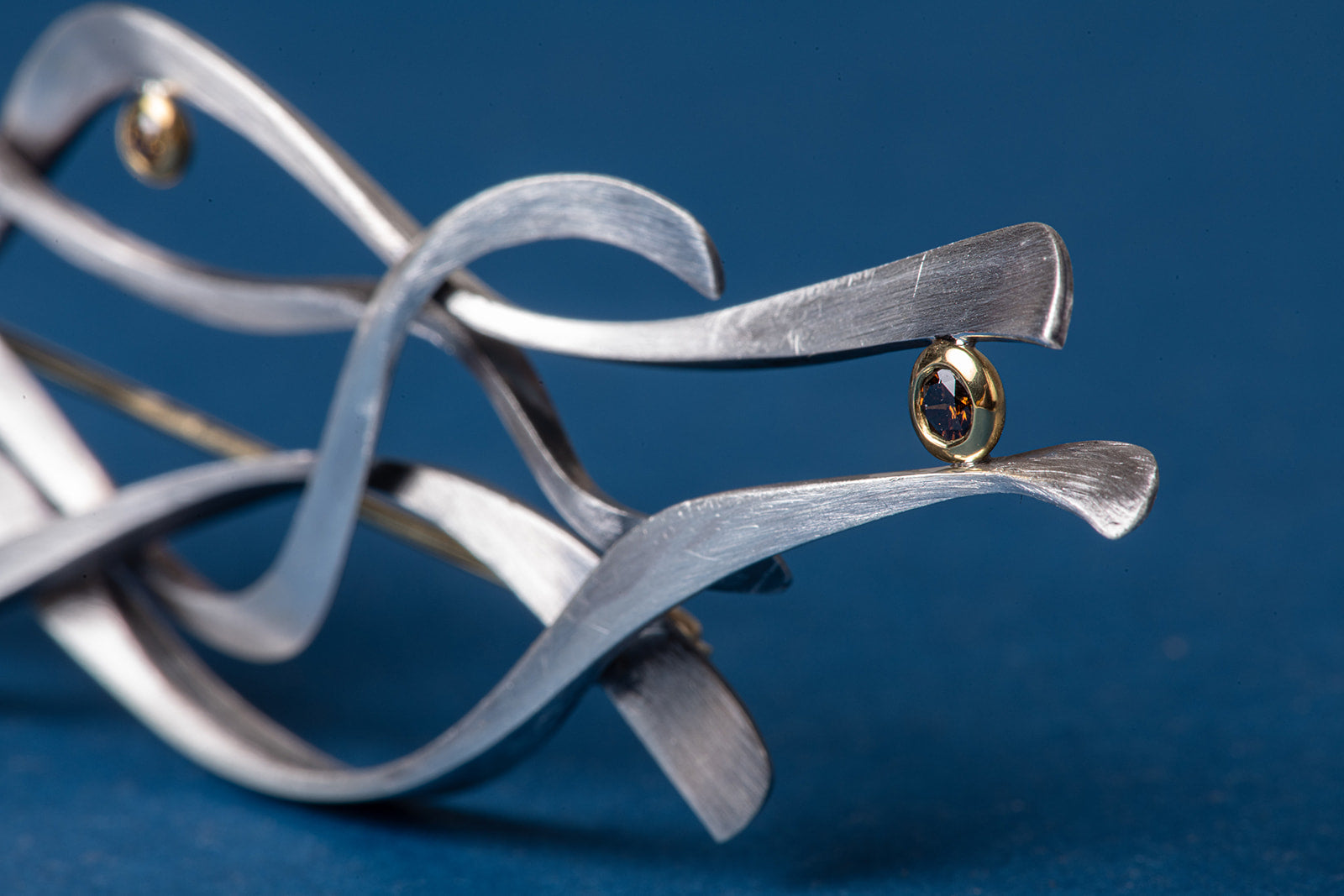 close up of diamond in abstract brooch
