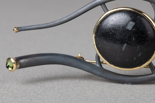 closeup, Eye of Horus brooch. Natural pebble set in gold and silver with tourmalines.
